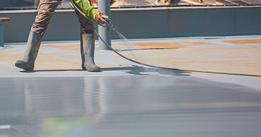 A male worker holding an industrial spray gun used